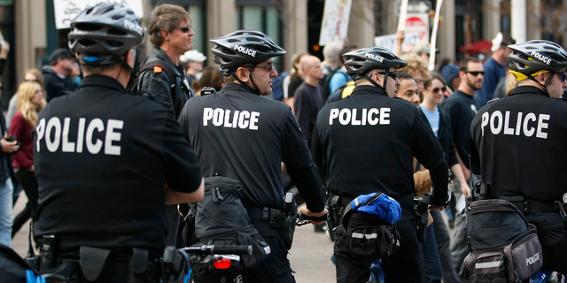 Police watch an Occupy Denver protest march through downtown Denver on Nov. 5, 2011.