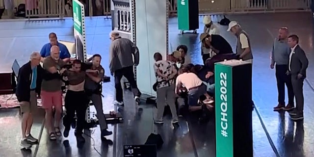 This still image from video shows Hadi Matar, 24, of Fairview, N.J., at left, being escorted from the stage as people tend to author Salman Rushdie, center right, at the Chautauqua Institution, in Chautauqua, N.Y., Friday, Aug. 12, 2022.
