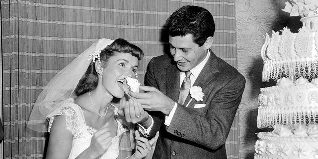 Singer Eddie Fisher feeds a piece of wedding cake to his bride, actress Debbie Reynolds, following their wedding at Grossinger's in Liberty, N.Y., Sept. 26, 1955.