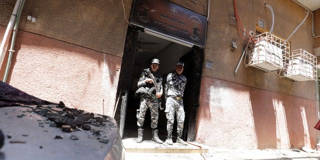 Security members stand at the scene where a deadly fire broke out at the Abu Sifin church in Cairo's Imbaba neighborhood on Sunday.