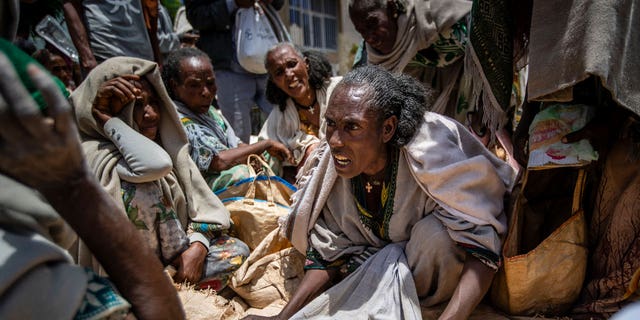 에티오피아 여성이 2021년 5월 8일 에티오피아 북부 티그레이 지역의 아굴라 마을에서 티그레이 상호부조회가 배분한 노란색 분할 완두콩 할당에 대해 다른 사람들과 논쟁하고 있습니다. 
