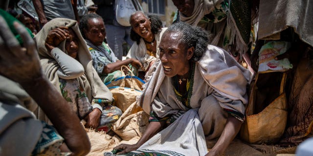 An Ethiopian woman argues with others over the allocation of yellow split peas after it was distributed by the Relief Society of Tigray in the town of Agula, in the Tigray region of northern Ethiopia on May 8, 2021.