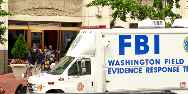 FBI personnel enter the Family Research Council office after a shooting in Washington August 15, 2012. A gunman wounded a security guard at the headquarters of the conservative Christian lobbying group, police said. Other guards wrestled the gunman to the ground and he was taken into custody. REUTERS/Kevin Lamarque
