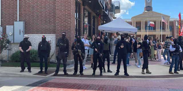 Armed protesters stand guard outside a drag show at Anderson Distillery &amp; Grill in Roanoke, Texas.