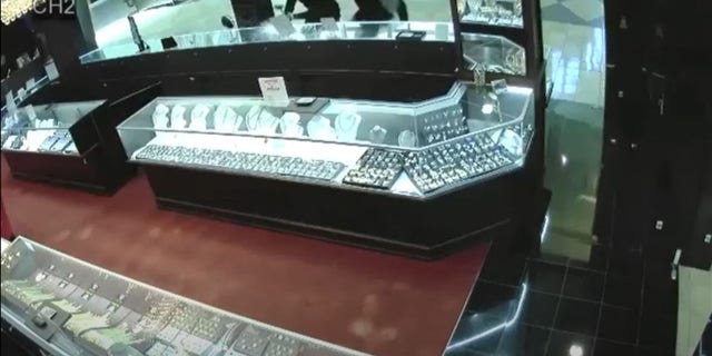 Surveillance video shows the men shattering glass display cases holding high-end watches with what appear to be hammers. 