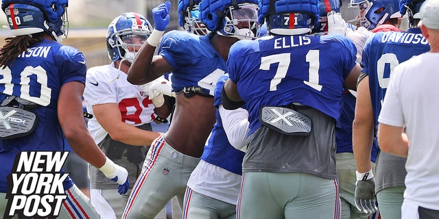 New York Giants linebacker Cam Brown, center, at the Giants' training facility in East Rutherford, New Jersey, Monday, Aug.  8, 2022 will throw a punch during a battle between offense and defense in training camp.  .
