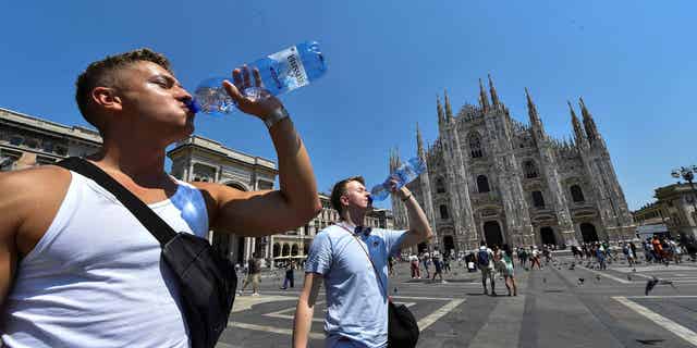 Pictured: Men drinking water to stay hydrated during heat wave in Milan, Italy, on July 21, 2022.