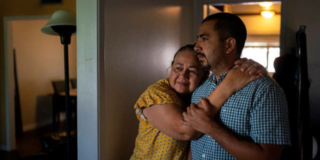 Ana Sandoval, mother of Eyvin Hernandez, a Los Angeles attorney who has been detained for five months in Venezuela, hugs her son Henry Martinez, Hernandez's half-brother, while posing for photos in Compton, Calif.,
