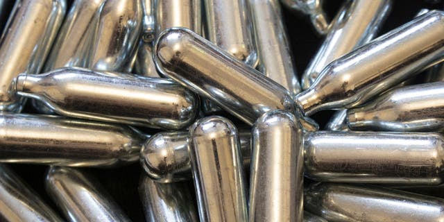 Nitrous oxide is a gas that can be packaged in metal bulb-shaped canisters like those shown here. Some people are buying these for recreational drug use.