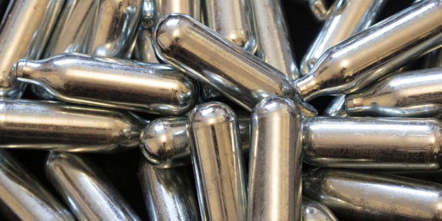 Nitrous oxide is a gas that can be packaged in metal bulb-shaped canisters like those shown here. Some people are buying these for recreational drug use.
