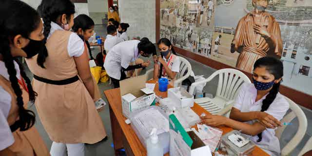 A girl receives a dose of Biological E's COVID-19 vaccine, Corbevax, in Ahmedabad, India, on March 16, 2022.