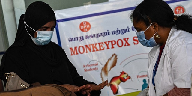 Medical workers at the Anna International Airport terminal in Chennai, India, check a passenger for symptoms of monkeypox in this picture taken June 3, 2022.