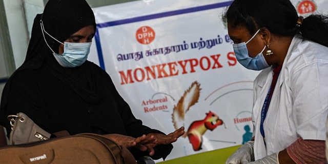 Medical workers at the Anna International Airport terminal in Chennai, India, check a passenger for symptoms of monkeypox in this picture taken June 3, 2022.