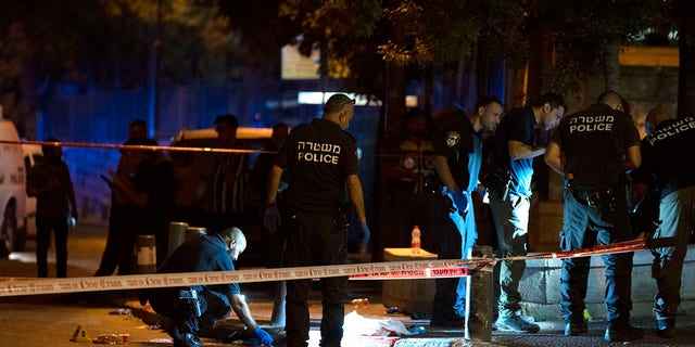 Israeli police crime scene investigators work at the scene of a shooting attack that wounded several Israelis near the Old City of Jerusalem early Sunday.