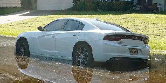 A sedan rests in floodwaters in this northeast Jackson, Miss., neighborhood, Monday, Aug. 29, 2022.