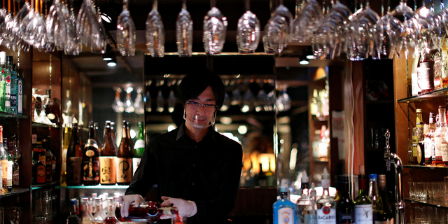 A bartender wearing a visor makes a cocktail, amid the COVID-19 outbreak, at a nightclub in Tokyo, Japan on Aug.6, 2020. 