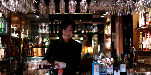 A bartender wearing a face shield makes a cocktail, amid the COVID-19 outbreak, at a night club in Tokyo, Japan August 6, 2020.Â