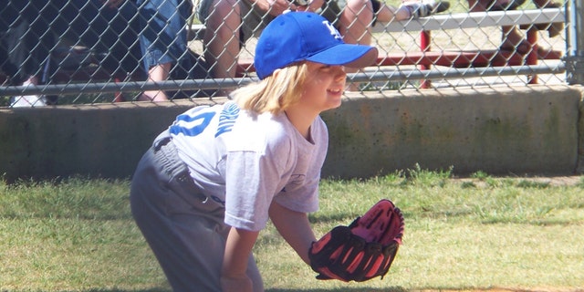 Sydney is photographed while playing in her team softball league.