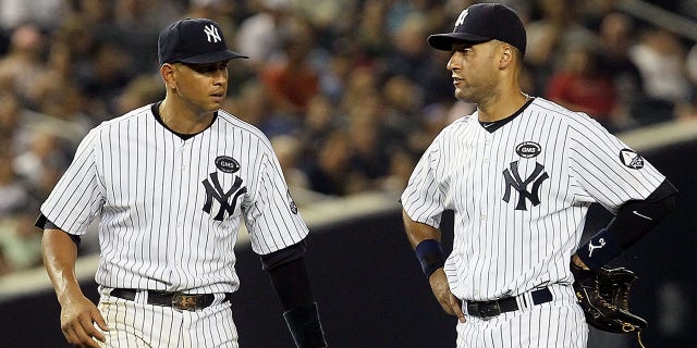 Derek Jeter, No. 2 (R) and Alex Rodriguez, No. 13 of the New York Yankees, watch a game against the Tampa Bay Rays on July 16, 2010 at Yankee Stadium in the Bronx, New York.