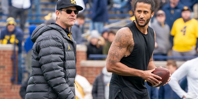 Colin Kaepernick, right, pictured with Michigan Wolverine head coach Jim Harbaugh at Michigan Stadium on April 2, 2022 in Ann Arbor, Michigan.