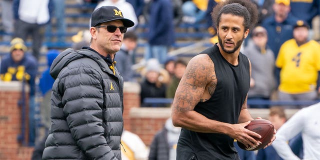 Colin Kaepernick, right, pictured with Michigan Wolverine head coach Jim Harbaugh at Michigan Stadium on April 2, 2022 in Ann Arbor, Michigan.