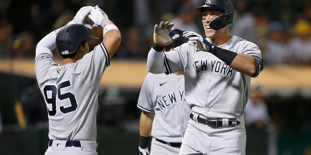Aaron Judge #99 of the New York Yankees celebrates with Oswaldo Cabrera #95 after hitting a three-run home run in the top of the fifth inning against the Oakland Athletics at RingCentral Coliseum on August 26, 2022 in Oakland, California.