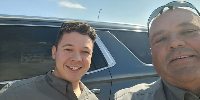 A Thrall Police Department officer snaps a selfie with Kyle Rittenhouse, left.