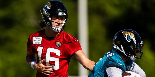 Trevor Lawrence (16) of the Jacksonville Jaguars hands the ball off to Travis Etienne during training camp on July 27, 2022, at Episcopal High School in Jacksonville, Florida.