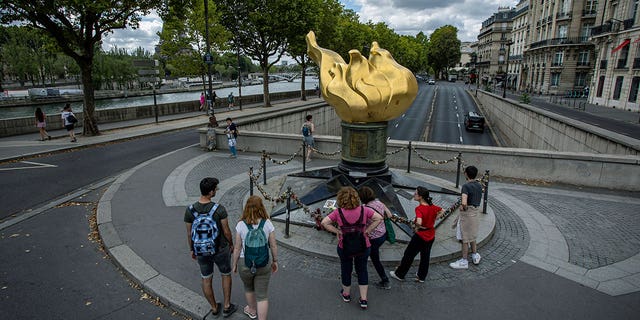 People stand by the gilded statue Flame of Liberty that serves as an unofficial shrine to Princess Diana, Monday Aug.  22, 2022 in Paris.  It has been nearly 25 years since Princess Diana died in a high-speed car crash in Paris.  The French doctor who treated her at the scene has recounted what happened.  Dr.  Frederic Mailliez told The Associated Press how he tried to save her on that night of Aug.  31, 1997. He remembers speaking English to her, giving here a respiratory bag and calling the emergency services.  Diana, her companion Dodi Fayed and their chauffeur died in a car crash in the Alma Tunnel next to the Seine River. 
