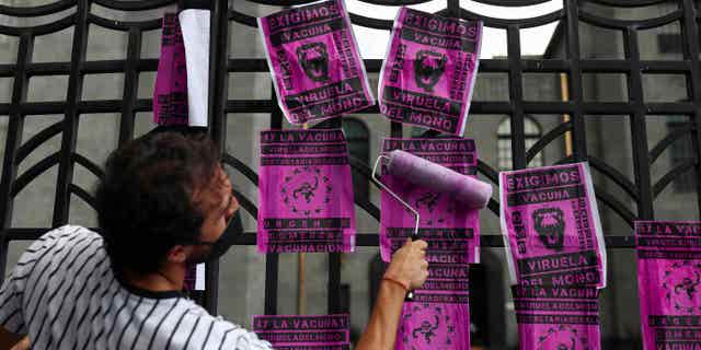 An activist holds up a poster protesting Mexico's handling of the monkeypox virus outside the Mexico Health Secretary's Building, Mexico City, Mexico, on July 26, 2022.