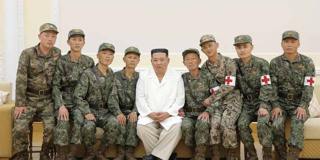 North Korean leader Kim Jung Un poses with military medics during a celebration of their contributions, in Pyongyang, North Korea, on Aug. 18, 2022.