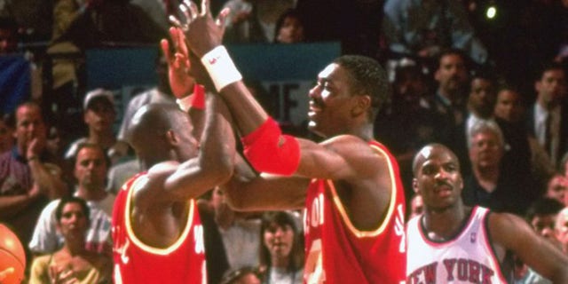 The Houston Rockets' Hakeem Olajuwon (34) and Vernon Maxwell (11) victorious on the court during a game against the New York Knicks at Madison Square Garden.