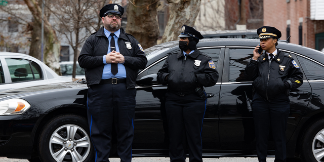Police and residents are pictured near the scene of the fatal fire in the Fairmount neighborhood on January 5, 2022, in Philadelphia, Pennsylvania.