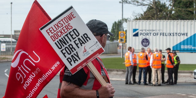 Management are seen discussing the dispute with CEO Clemence Cheng (in orange vest and black baseball cap) near the main gate of Felixstowe port as an eight day strike, called by the UNITE trade union begins over pay on August 21.