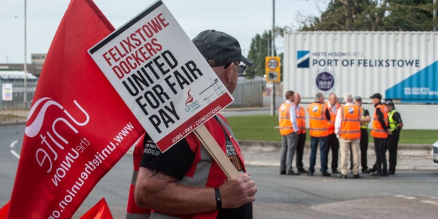 Management are seen discussing the dispute with CEO Clemence Cheng (in orange vest and black baseball cap) near the main gate of Felixstowe port as an eight day strike, called by the UNITE trade union begins over pay on August 21.