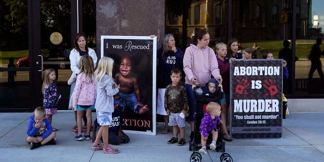 Abortion opponents are seen outside as the Michigan Board of State Canvassers meet during a hearing, Wednesday, Aug. 31, 2022, in Lansing, Mich. 