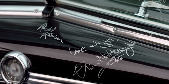 Newton-John and "Grease" director Randal Kleiser autographed the dashboard.