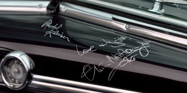 Newton-John and "Grasso" director Randal Kleiser autographed the dashboard.