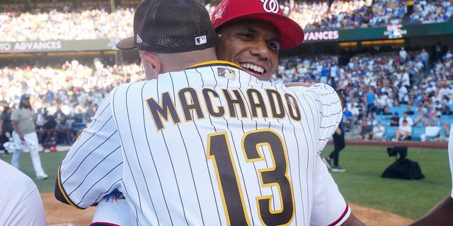 Juan Soto of the Washington Nationals hugs Manny Machado (13) of the San Diego Padres during the T-Mobile Home Run Derby at Dodger Stadium July 18, 2022, 在洛杉矶.