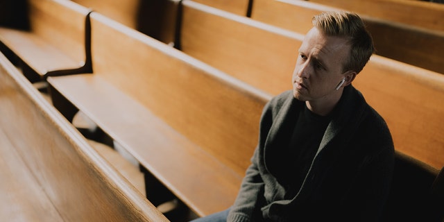 Hallow app creator Alex Jones sits in the pews of a church. He was interested in combining meditation and faith into one Catholic app — and launched his creation in late 2018.