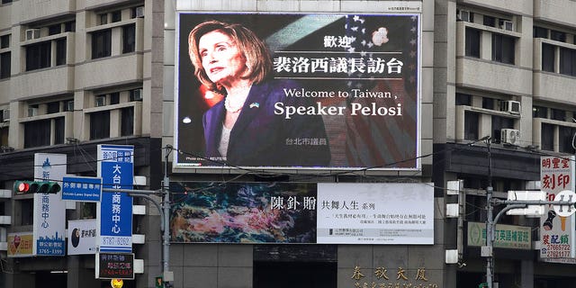 People walk past a sign welcoming US House Speaker Nancy Pelosi in Taipei, Taiwan, August 3, 2022.