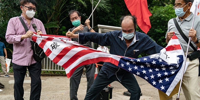 중국 시위대가 2022년 8월 3일 중국 홍콩의 미국 총영사관 앞에서 성조기를 찢고 있다.