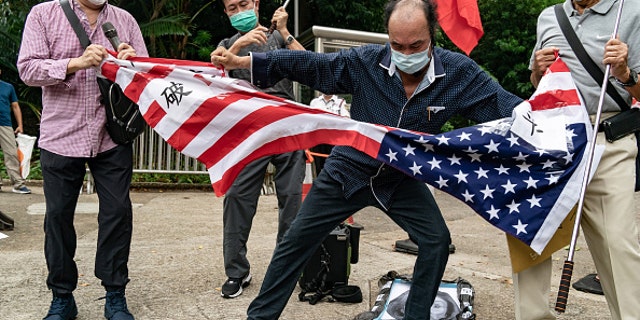 Chinese protesters tear up an American flag outside the Consulate General of the United States in Hong Kong on Wednesday, Aug. 3, 2022.