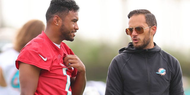 Head coach Mike McDaniel of the Miami Dolphins, right, talks with Tua Tagovailoa during training camp at the Baptist Health Training Complex on July 27, 2022, in Miami Gardens, Florida.