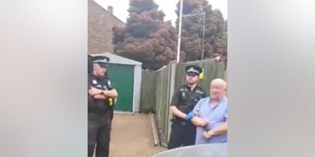 Hampshire police with Army veteran Darren Brady in handcuffs outside his home. 