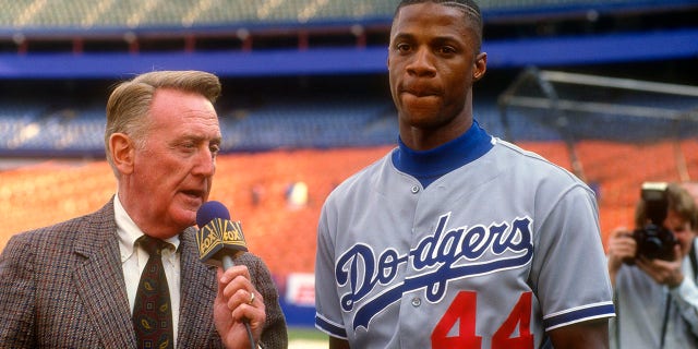 Darryl Strawberry #44 of the Los Angeles Dodgers get interviewed by Vince Scully prior to the start of a Major League Baseball game against the New York Mets circa 1991 at Shea Stadium in the Queens borough of New York City. Strawberry played for the Dodgers from 1991-93.