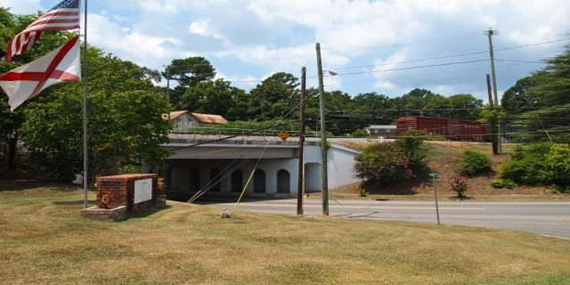 An American flag and Alabama state flag are on display near an underpass, in the town of Vincent, Alabama.