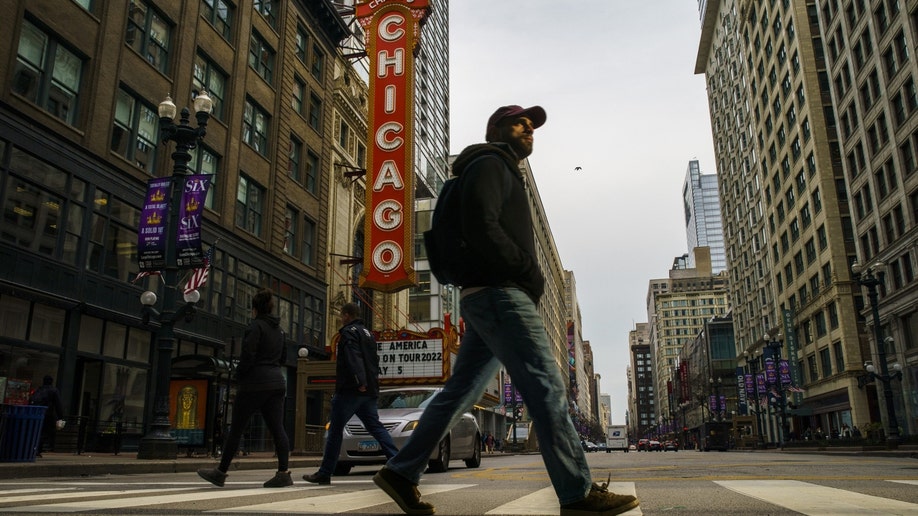 People walk in the Loop the day after a 27-year-old man and 55-year-old man were shot near the the Chicago Theatre, Monday, May 2, 2022, in Chicago