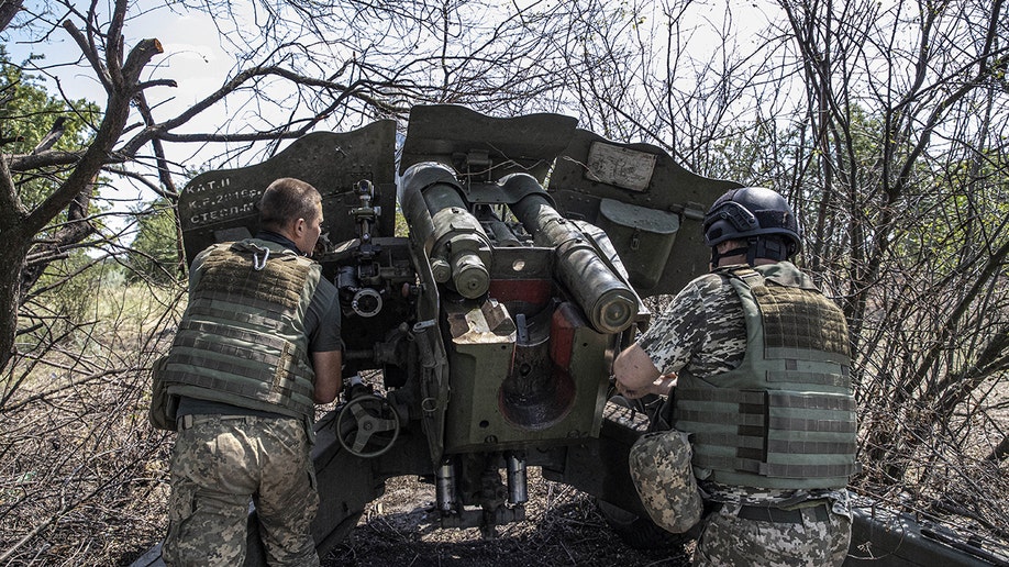 Ukrainian artillerymen near an artillery cannon