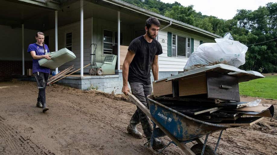 A young couple in Squabble Creek, Kentucky, near Buckhorn, removes items damaged by water from their home